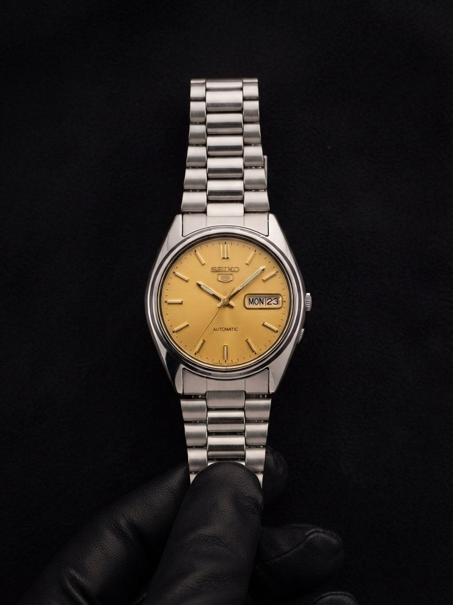 Altın sarı kadranlı Seiko 5 otomatik saatin ön görünümü