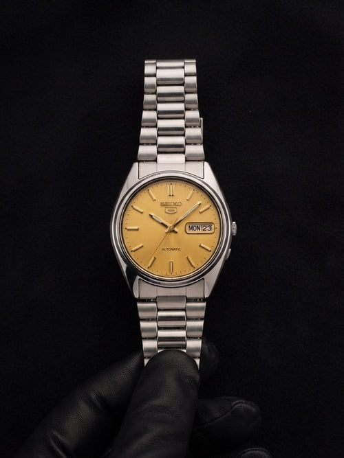 Altın sarı kadranlı Seiko 5 otomatik saatin ön görünümü